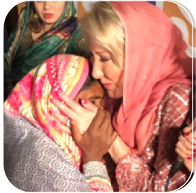 Photo of Pastor Hope praying with a woman during a missions trip.